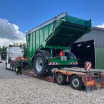 A GreenLoader with its body raised, carried on a low-loader truck.