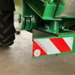 A red-and-white striped plate on the lower frame beside a GreenLoader wheel.