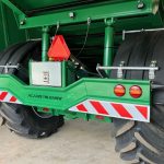 Rear of a GreenLoader indoors, with twin wheels, round lights and a striped bumper.