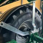 A metal linkage bolted across the front of a GreenLoader wheel.
