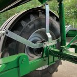 A linkage arm crossing above a GreenLoader wheel.