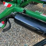 A black hydraulic cylinder mounted along the GreenLoader frame.