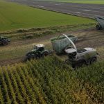 Aerial view of several GreenLoaders and forage harvesters working across a maize field.