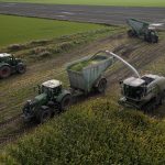 Aerial view of two GreenLoaders and a forage harvester in a partly cut maize field.