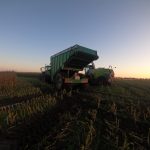 A GreenLoader with its body raised, seen from behind in maize stubble at sunset.