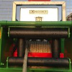 Wire rope leaving the drum and passing over black guide rollers on a PowerWinch.
