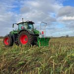 A Fendt tractor with a PowerWinch driving through a standing green crop.