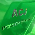 Close-up of raised lettering that reads ACJ Power Winch on a green panel.