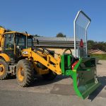 Rear view of a yellow JCB loader fitted with a green PowerWinch and blade.