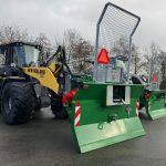 A yellow New Holland loader fitted with a PowerWinch and blade.