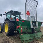 Rear view of a John Deere tractor with a muddy PowerWinch blade.