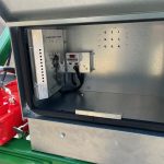 Open lid of a Twin Power compartment showing a control box and red motor.
